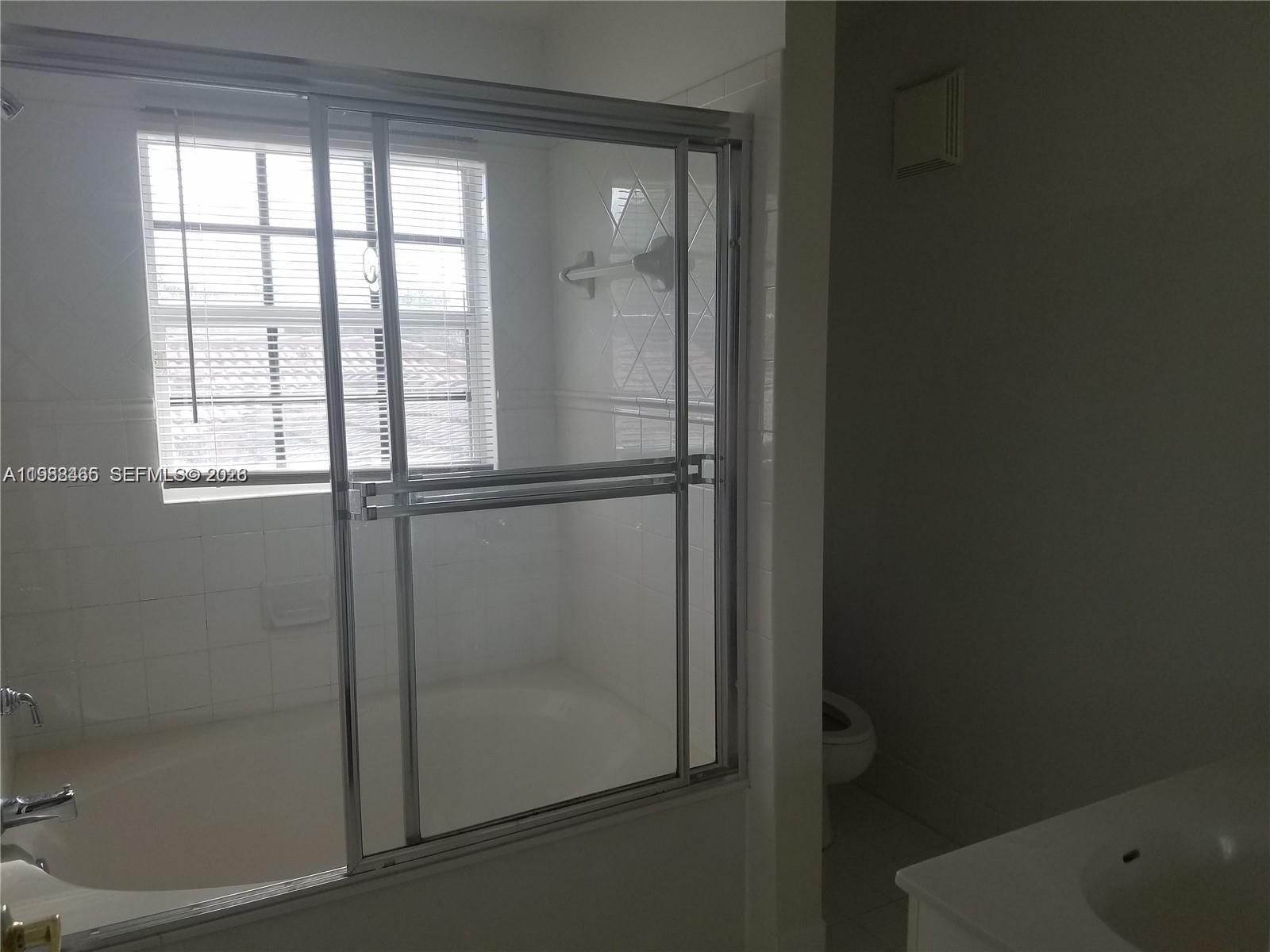 18741 Southwest 25th Court Miramar, FL 33029 - Photo 19 of 32 a bathroom with a glass shower door