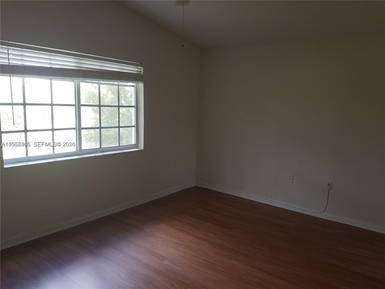 18741 Southwest 25th Court Miramar, FL 33029 - Photo 21 of 32 a view of an empty room with wooden floor and a window