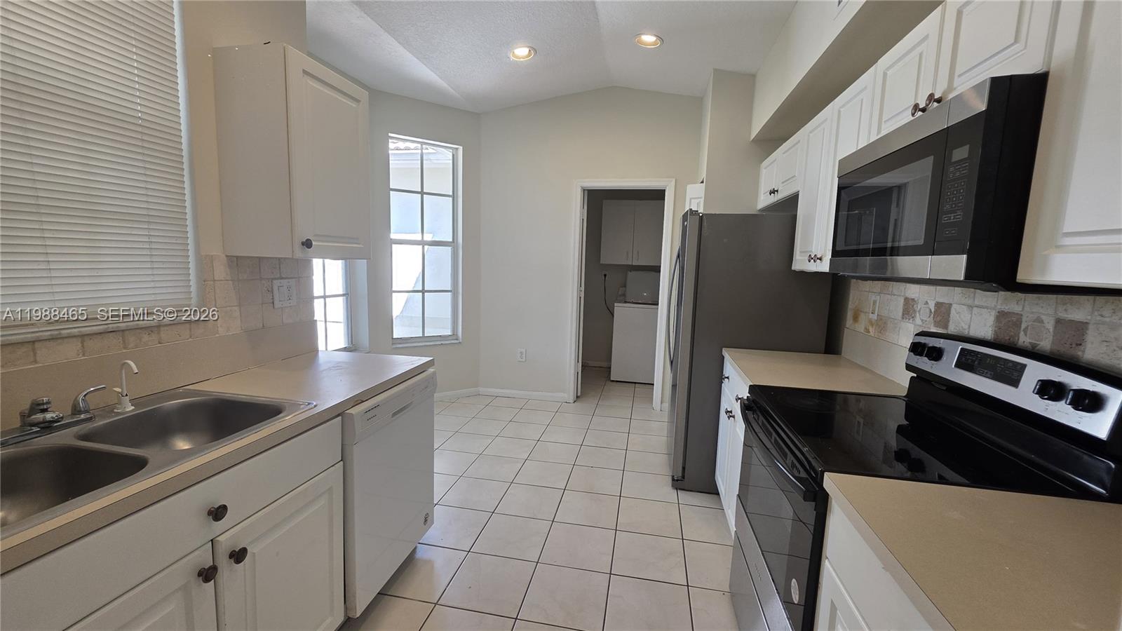 18741 Southwest 25th Court Miramar, FL 33029 - Photo 26 of 32 a kitchen with stainless steel appliances a sink stove and microwave