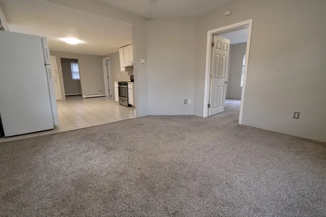 a view of empty room with furniture and refrigerator