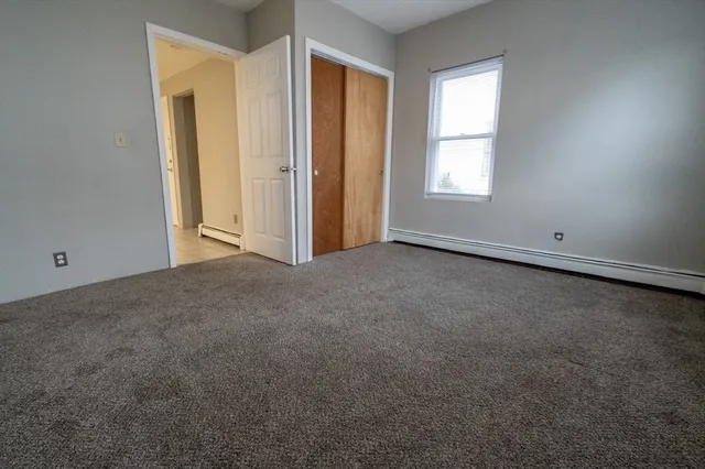 an empty room with windows and closet