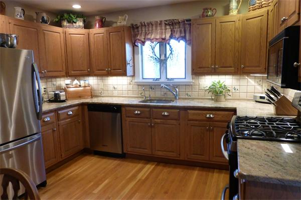 305 Sterling Road Lancaster, MA 01523 - Photo 4 of 21 a kitchen with wooden cabinets a sink a stove a refrigerator and cabinetry