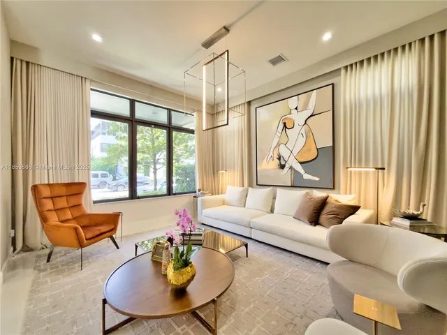 a view of a dining room with furniture a potted plant and wooden floor