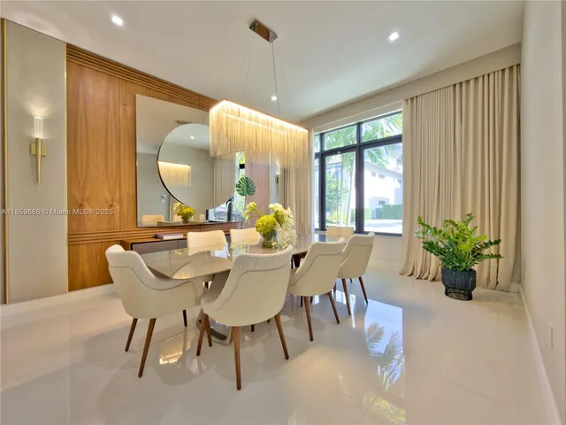 a kitchen with stainless steel appliances kitchen island granite countertop a table chairs and a refrigerator