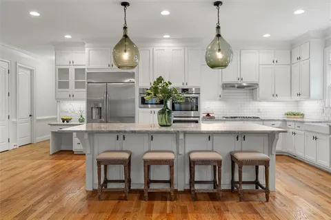 a dining room with furniture a chandelier and wooden floor