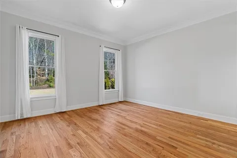 an empty room with windows and chandelier fan