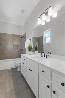 a bathroom with a sink a toilet a tub and shower