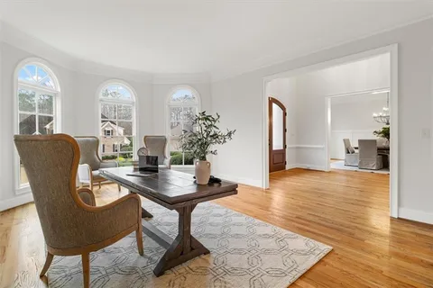 a view of a hallway with wooden floor and furniture