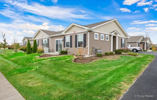 a front view of a house with a yard and trees