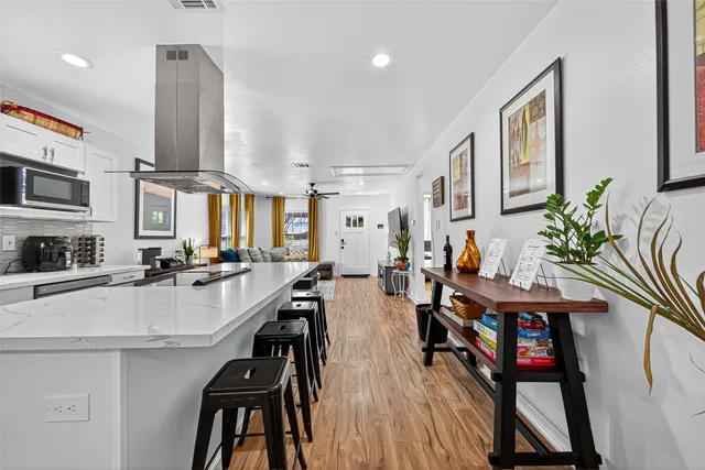 a very nice looking dining room with kitchen island furniture a large window and a kitchen view