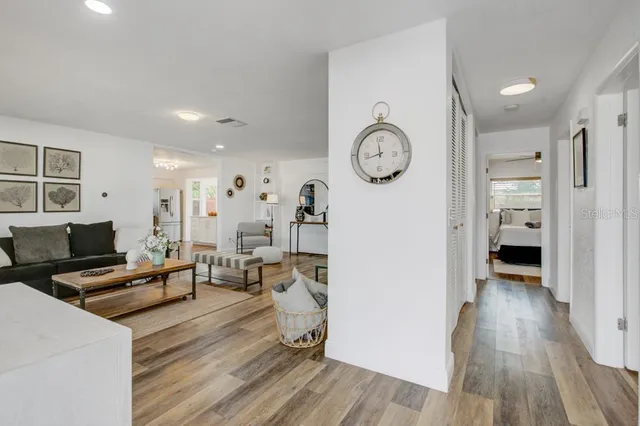 a living room with furniture a wooden floor and a clock