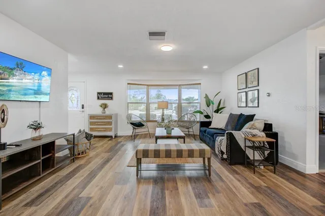 a living room with furniture a rug and a flat screen tv