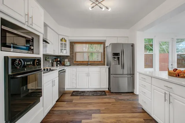 a kitchen with stainless steel appliances a refrigerator stove and microwave