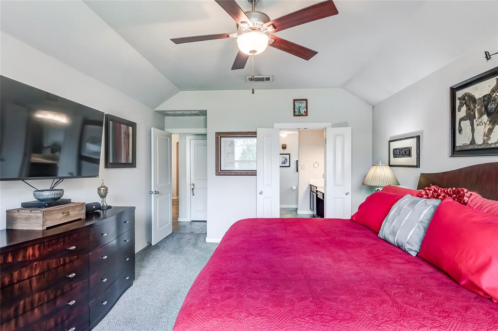 231 Windswept Way Kyle, TX 78640 - Photo 12 of 33 Bedroom with vaulted ceiling, carpet flooring, ensuite bath, and a ceiling fan