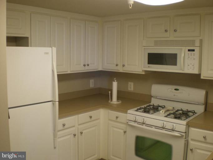 11710 Old Georgetown Road, Unit 408 Rockville, MD 20852 - Photo 7 of 27 a stove top oven sitting inside of a kitchen