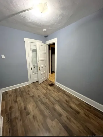 an empty room with wooden floor and closet