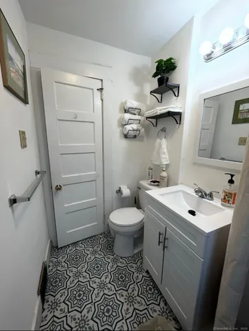 a bathroom with a sink a toilet and shower
