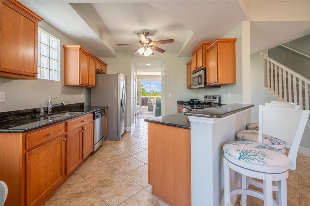 3230 Mangrove Point Drive Ruskin, FL 33570 - Photo 12 of 44 a kitchen with stainless steel appliances kitchen island granite countertop a sink cabinets and wooden floor