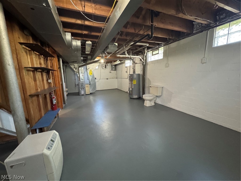 145 Anna Avenue Northwest Canton, OH 44708 - Photo 21 of 27 Spacious unfinished basement featuring painted concrete flooring, exposed ceiling joists, and block glass windows