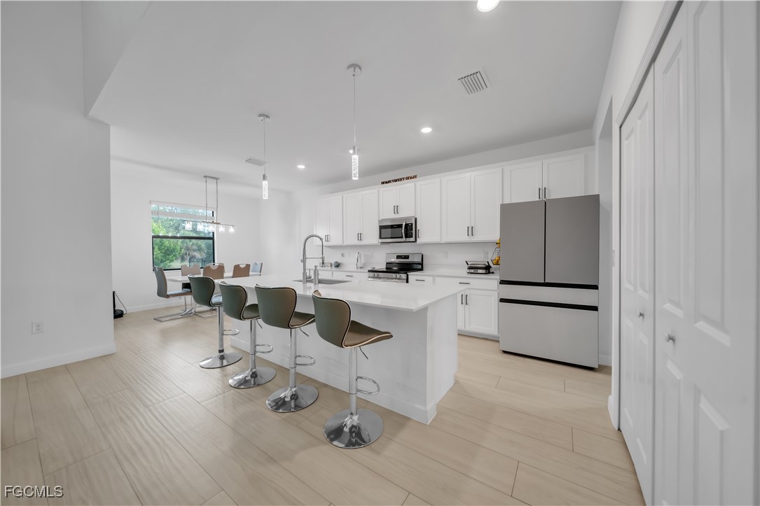 11264 Canopy Loop Fort Myers, FL 33913 - Photo 13 of 49 a kitchen with white cabinets and stainless steel appliances