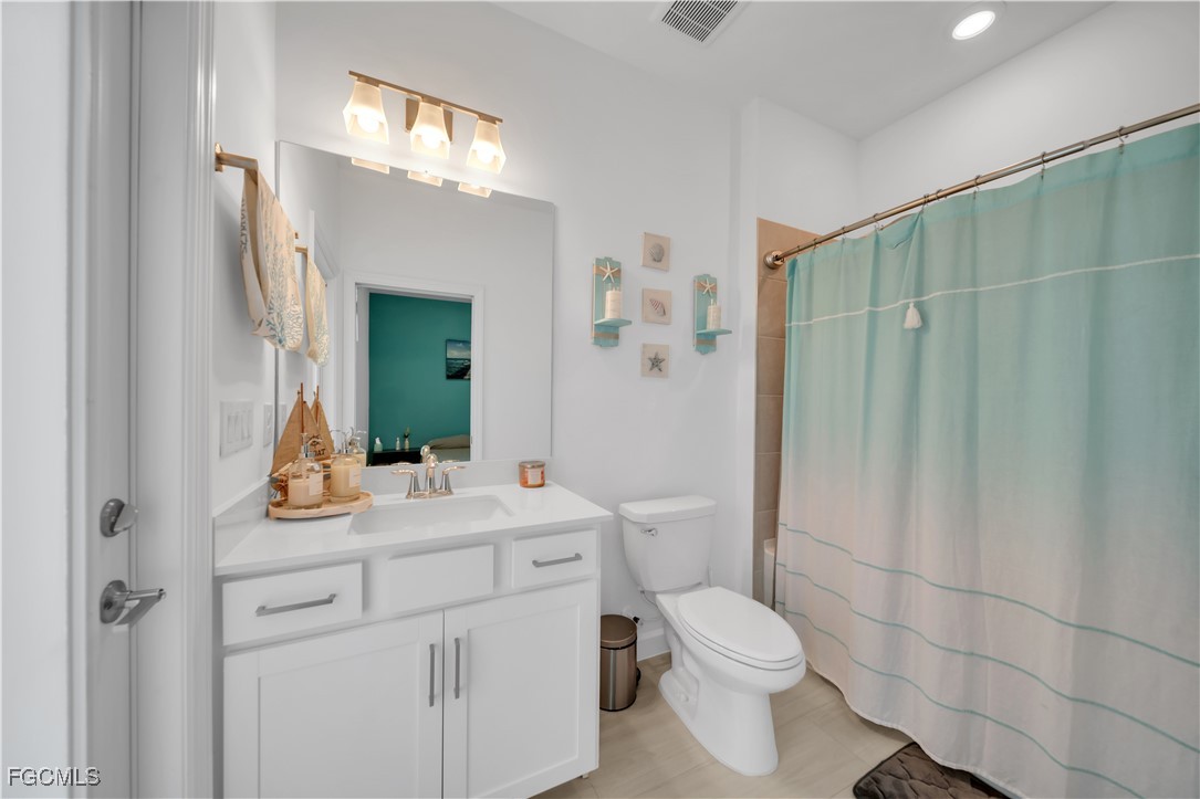 11264 Canopy Loop Fort Myers, FL 33913 - Photo 25 of 49 a bathroom with a toilet sink vanity and mirror