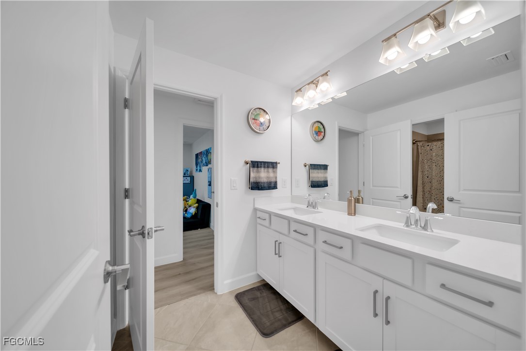 11264 Canopy Loop Fort Myers, FL 33913 - Photo 46 of 49 a spacious bathroom with a double vanity sink and a mirror
