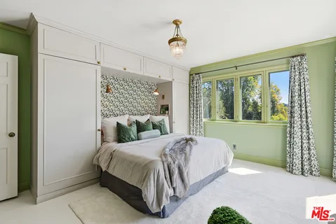 a bedroom with bed couch and window