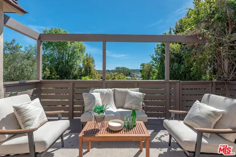 a view of a patio with chairs under an umbrella