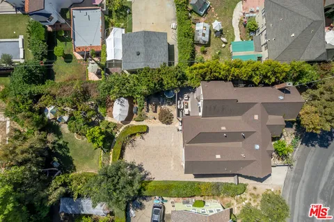 a backyard of a house with table and chairs under an umbrella