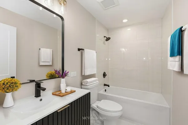 a bathroom with a granite countertop sink mirror vanity and toilet