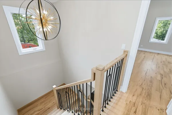 an entryway with wooden floor mirror and a window