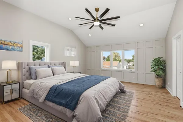 a spacious bedroom with a large bed a chandelier and a window