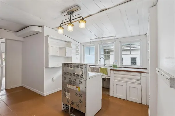 an empty room with staircase and windows