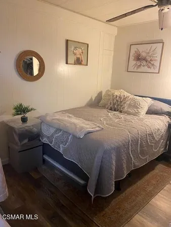 a bedroom with a bed and a painting on the wall