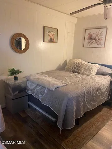 a bedroom with a bed and a painting on the wall
