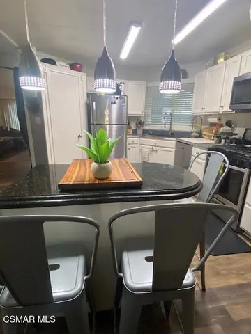 a kitchen with stainless steel appliances granite countertop a sink a stove and a refrigerator