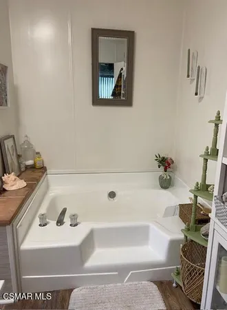 a bathroom with a tub sink and mirror