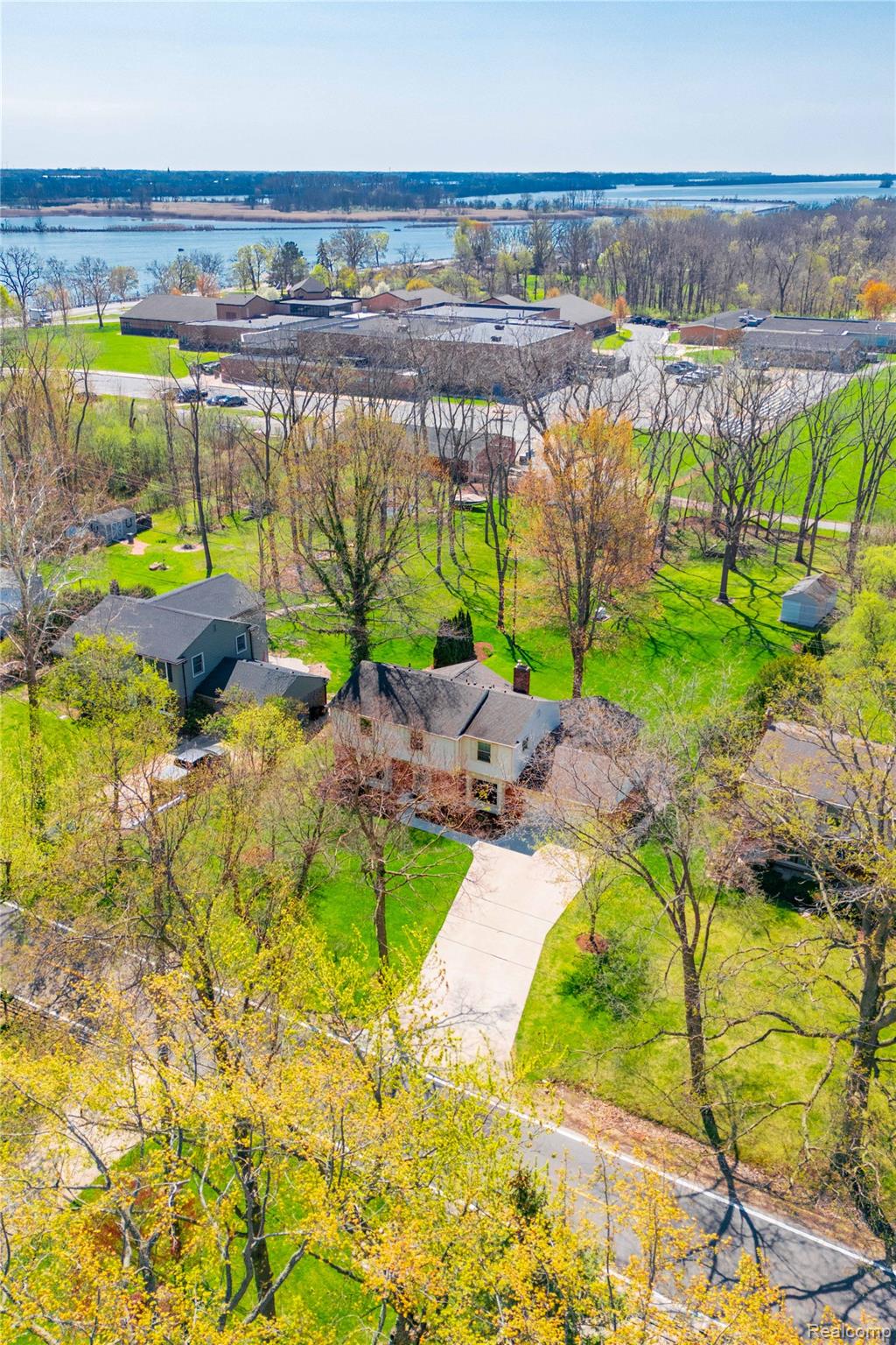 7611 Ferry Road Grosse Ile, MI 48138 - Photo 7 of 51 Traditional two-story residence featuring a paved driveway, verdant lawn, and mature trees