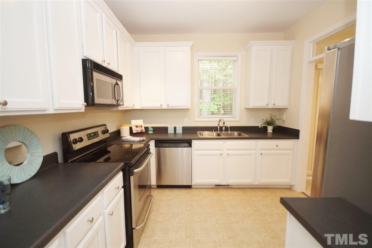 5209 Groveside Court Raleigh, NC 27613 - Photo 11 of 25 a kitchen with a sink a stove and cabinets
