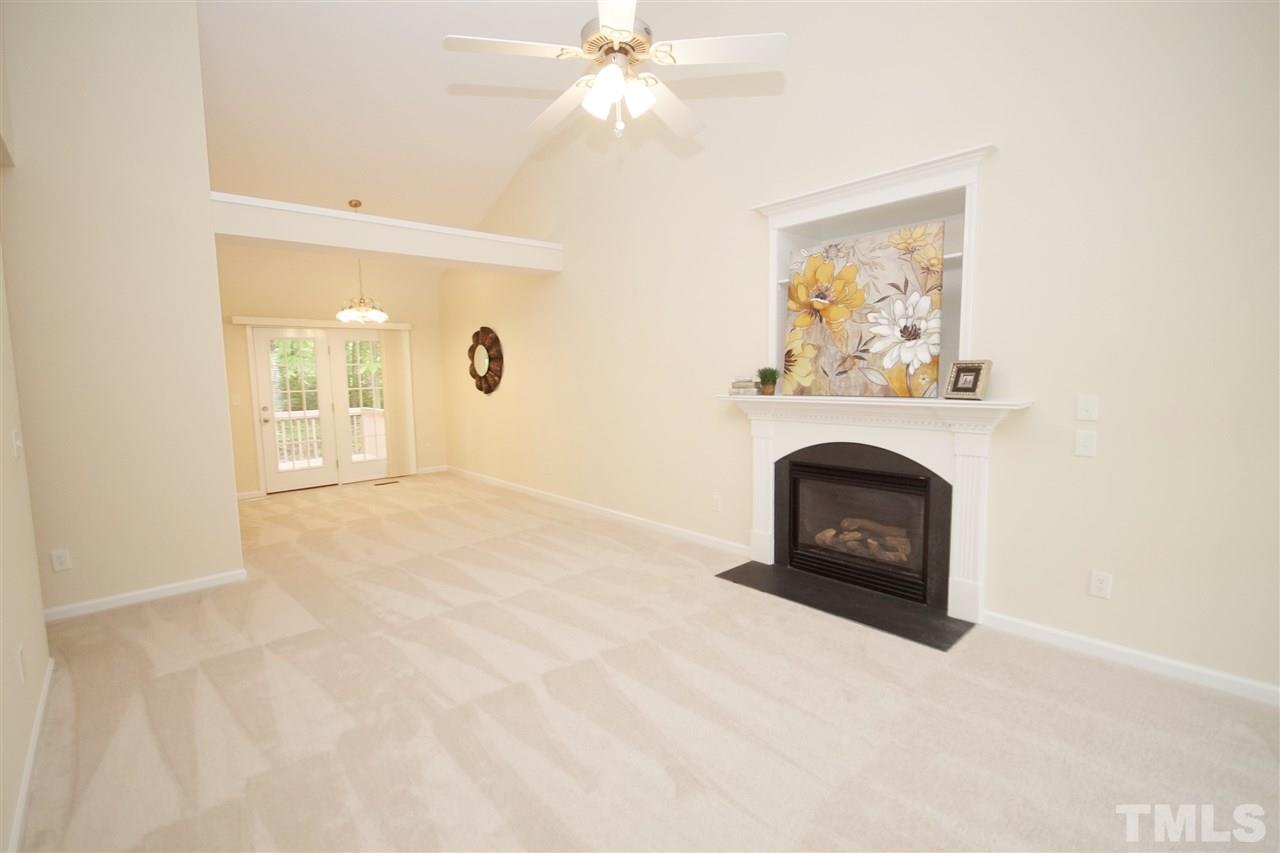 5209 Groveside Court Raleigh, NC 27613 - Photo 3 of 25 an empty room with fireplace and wooden floor