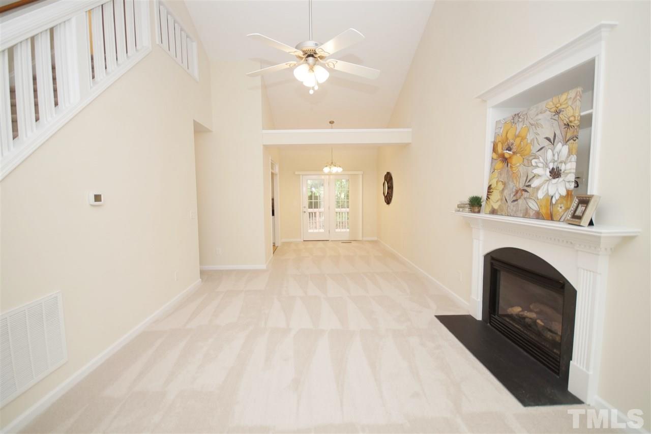 5209 Groveside Court Raleigh, NC 27613 - Photo 4 of 25 a view of a livingroom with a fireplace a chandelier fan and wooden floor