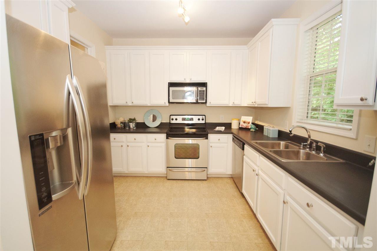 5209 Groveside Court Raleigh, NC 27613 - Photo 10 of 25 a kitchen with stainless steel appliances granite countertop a refrigerator a sink a stove a microwave a counter space and cabinets
