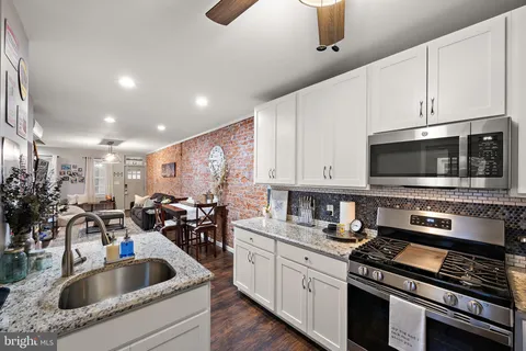 a kitchen with stainless steel appliances kitchen island granite countertop a sink a stove and cabinets