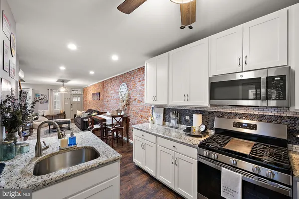 a kitchen with stainless steel appliances kitchen island granite countertop a sink a stove and cabinets