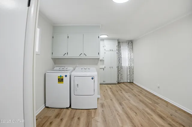 a utility room with wooden floor washer and dryer