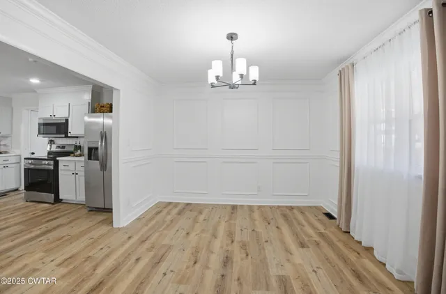 a view of a kitchen with wooden floor and stainless steel appliances