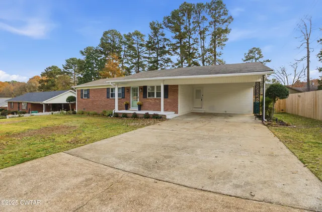 a front view of a house with a yard and potted plants