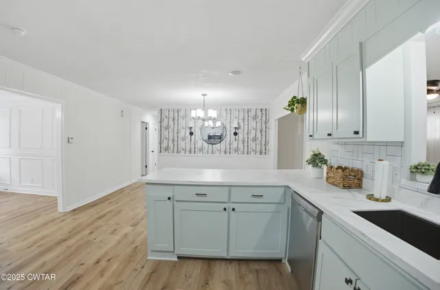 a kitchen with white cabinets and sink