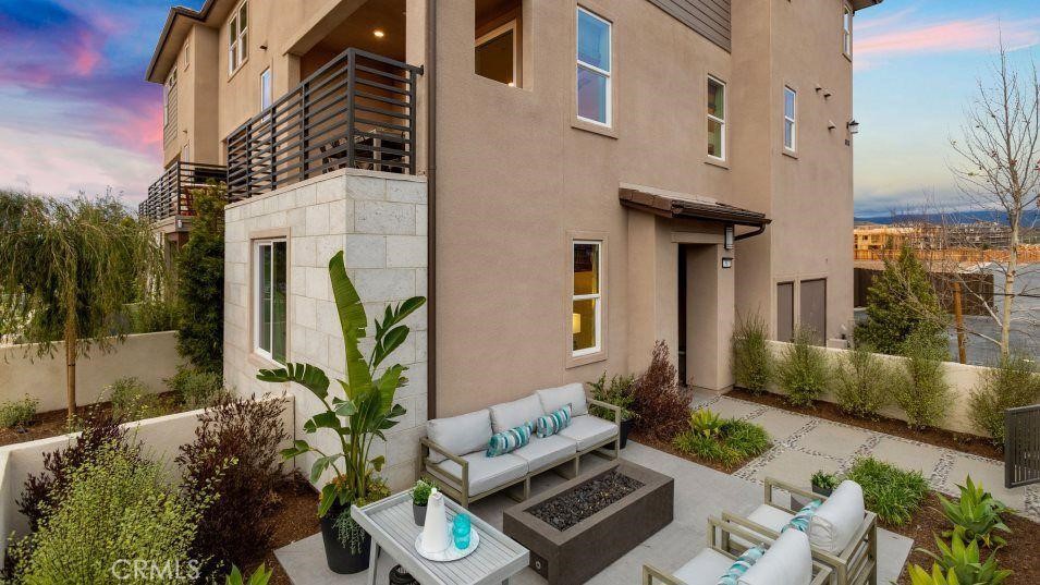 a view of a patio with couches table and chairs and potted plants