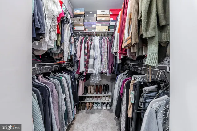 a view of walk in closet with clothes
